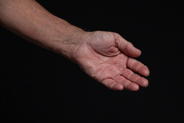 The outstretched hand of a caucasian man, isolated on black background.