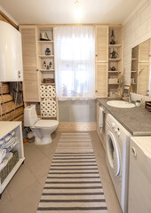 toilet room in wooden house with a toilet bowl, a boiler and a washing machine. in a light rustic style.