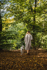 Junge Frau mit Dalmatiner Junghund / Welpe im Herbst spazieren