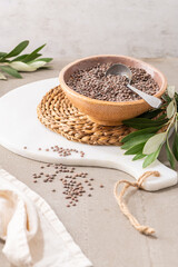 Uncooked raw green lentil in ceramic bowl with a spoon in kitcehn countertop.  For healthy food and diet concepts.