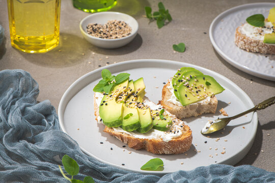 Healthy toast with avocado cream cheese and wheat bread on a plate. Delicious snacks and avocado sandwiches. Food composition, tasty Italian meal.