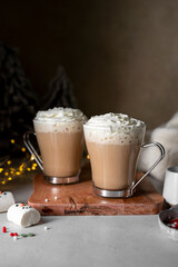 Hot chocolate glass cup with snowman marshmallows. Seasonal, winter or Christmas comfort coffee drinks.