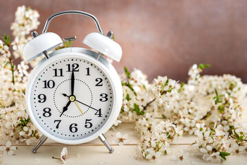 Retro alarm clock and spring flowers