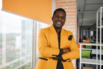 portrait of a successful african man in a yellow jacket in the office