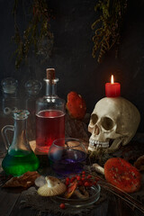 Still life in a low key - a table with attributes of witch spells and charms