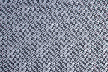 Close-up of diamond-patterned textured synthetic fabric used to make blinds. Design template or polyester material abstract background