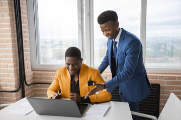 two african businessmen working in the office with a laptop