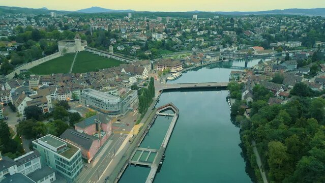 Fly backwards above Rhein river in the city centre of Schaffhausen, during blue hour