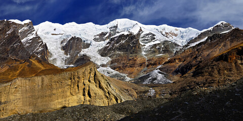 Glacier moraine on the background of icefall and snow-covered mountains. French camp on Dhaulagiri circuit trek.