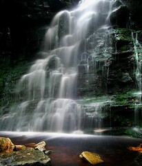 Vertical shot of amazing cascade flowing waterfall. Great for wallpaper