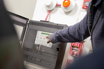 Pull station fire alarm system and mock sprinklers attached to a white wall used for training of security guards. 