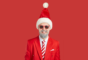 Portrait of happy guy in Christmas costume. Man with grey beard wearing red suit, striped red white...