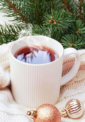 Obraz na płótnie Canvas Winter, Christmas, New Year decorations composition, concept, background. White Mug, cup of tea, coffee, steam, spruce branches, knitted plaid. Christmas mood morning. Christmas greeting card.