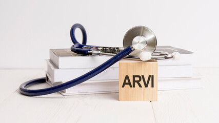 The word ARVI is written on wooden cube near a stethoscope on a white background. ARVI - short for Acute Respiratory Viral Infection. Medical concept.