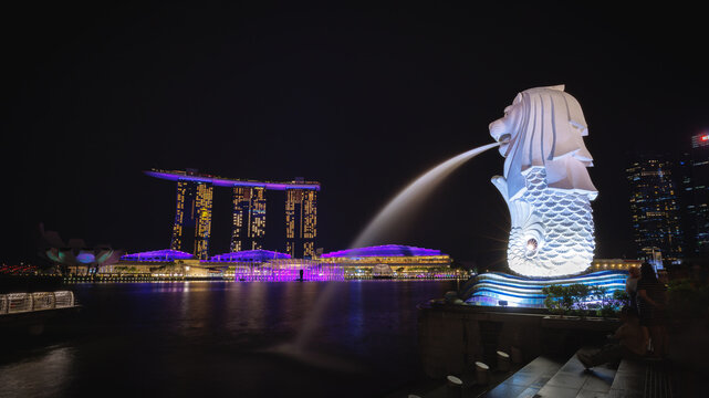 Merlion Part, Singapore - October 8, 2022: Marina bay view at night with Merlion and Marina Bay Sand building and esplanade in the background. Singapore landmark after opening country for tourist.