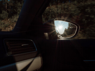 Car mirror or side rear view mirror with reflection of beautiful sunset