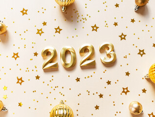 Greeting card - happy new year with numbers 2023, gold glitter and christmas balls on beige...