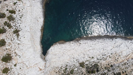 Bird's eye view of an angular bay with white cliffs and a calm sea in the south of Thassos island....