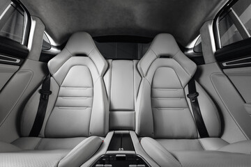 Luxury car rear seats row. Expensive car leather seats. White and comfortable sport seats for...