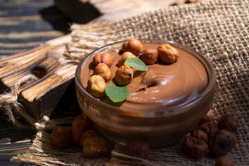 Chocolate spread with hazelnuts on a dark background