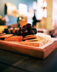 A cheese board with large red grapes