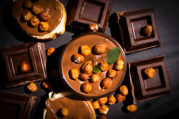 Chocolate spread with hazelnuts on a dark background