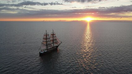 Aerial shot of an old sailing ship into the sunset