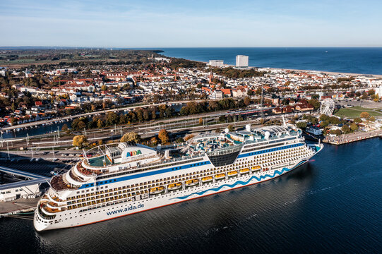 Rostock, Warnemuende, Germany - October 2022, The cruise ship "AIDA diva" of AIDA Cruises has moored at the Cruise Ship Terminal - the city of Warnemuende with its landmarks in the background - aerial