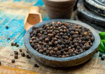 Indian spices collection, dried black peppercorns and another spices in clay bowls