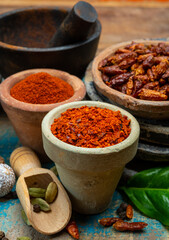 Colorful ground spicy chili peppers , pimento and curcuma is clay pots close up