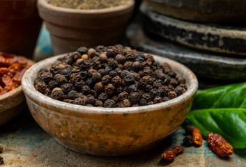 Indian spices collection, dried black peppercorns and another spices in clay bowls