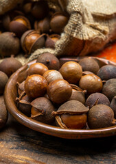 New harvest of ripe fresh Australian macadamia nuts in shell with leaves