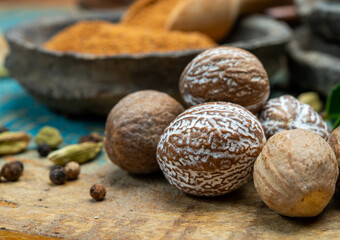 Nutmeg powder. Macro view whole nuts and grated muscat nuts on vintage background.