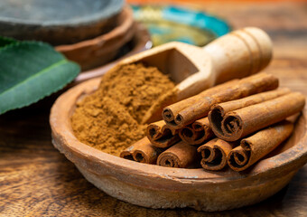 Indian spices collection, dried aromatic cinnamon barks and another spices in clay bowls