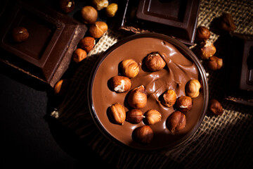 Chocolate spread with hazelnuts on a dark background