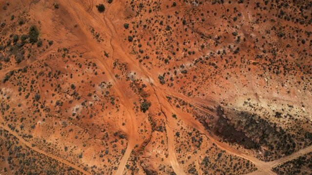 Aerial drone bird's eye view of desert dirt road.