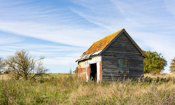 old farm building on agricultural land, open farmland blue skys