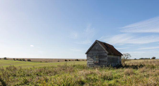 old farm building on agricultural land, open farmland blue skys
