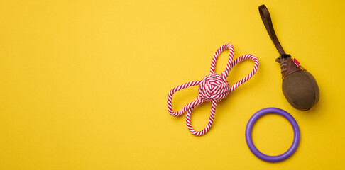 Textile toy, rope for playing with animals on a yellow background, top view.