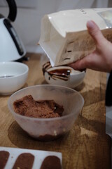 Pastry chef hands draws with a brush golden bear and horse
