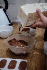 Pastry chef hands draws with a brush golden bear and horse
