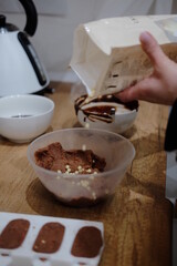 Pastry chef hands draws with a brush golden bear and horse
