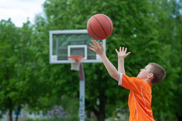 Boy playing basketball on a park court. Concept of a sports lifestyle, training, camp, leisure, vacation. Horizontal sport theme poster, greeting cards, headers, website and app