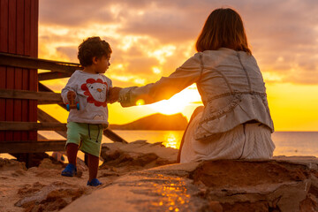 Mother with her son on vacation at sunset in Cala Comte beach on the island of Ibiza. Balearic
