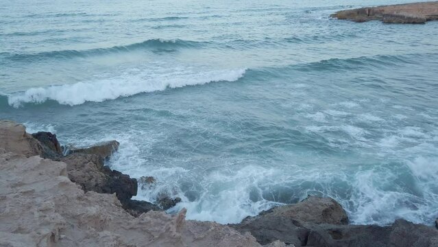 Waves hitting rocks on the shore in Spain