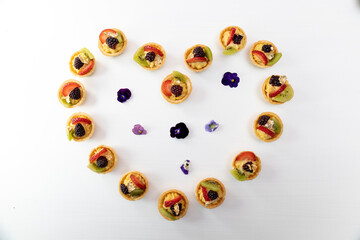 beautiful cakes with fruits forming a heart in the studio, delicious snack, background with an approach to fresh food, shapes
