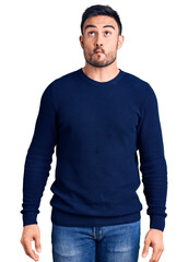 Fototapeta premium Young handsome man wearing casual clothes making fish face with lips, crazy and comical gesture. funny expression.