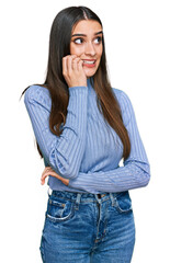 Young beautiful woman wearing casual winter sweater looking stressed and nervous with hands on...