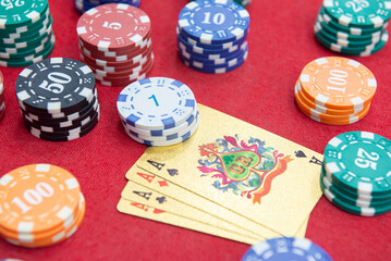 Four of aces near stacks of chips on a red felt table