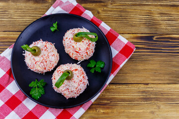Appetizer of crab-cheese balls made in a shape of Christmas baubles on wooden table. Top view